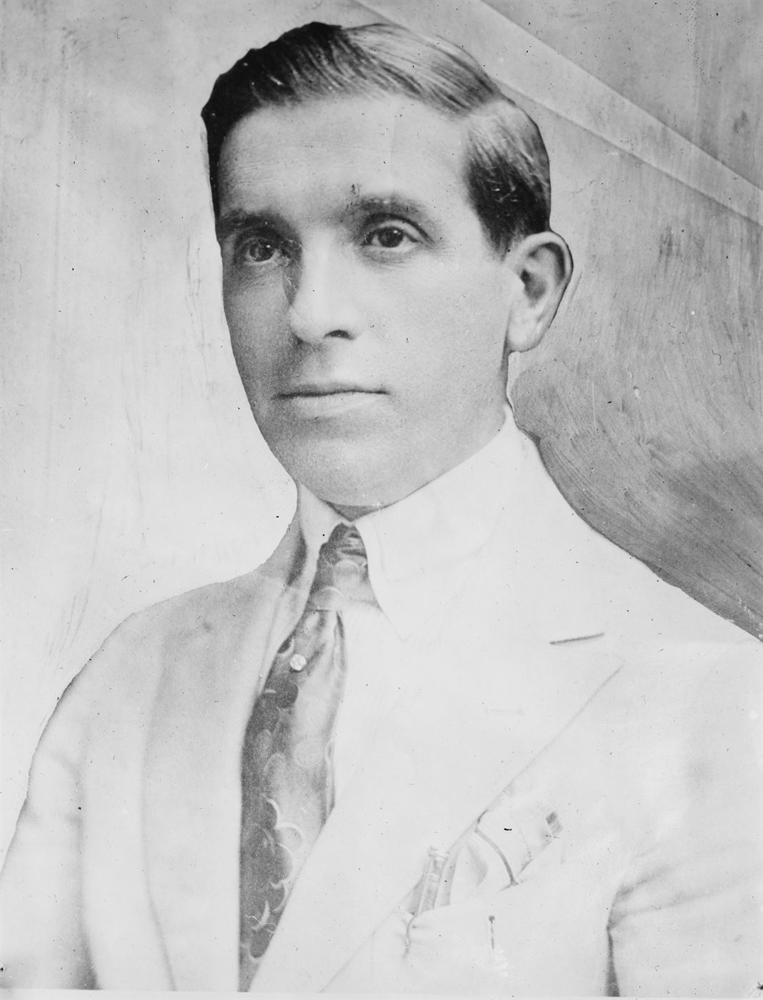 A 1920 portrait photograph of Charles Ponzi in a suit